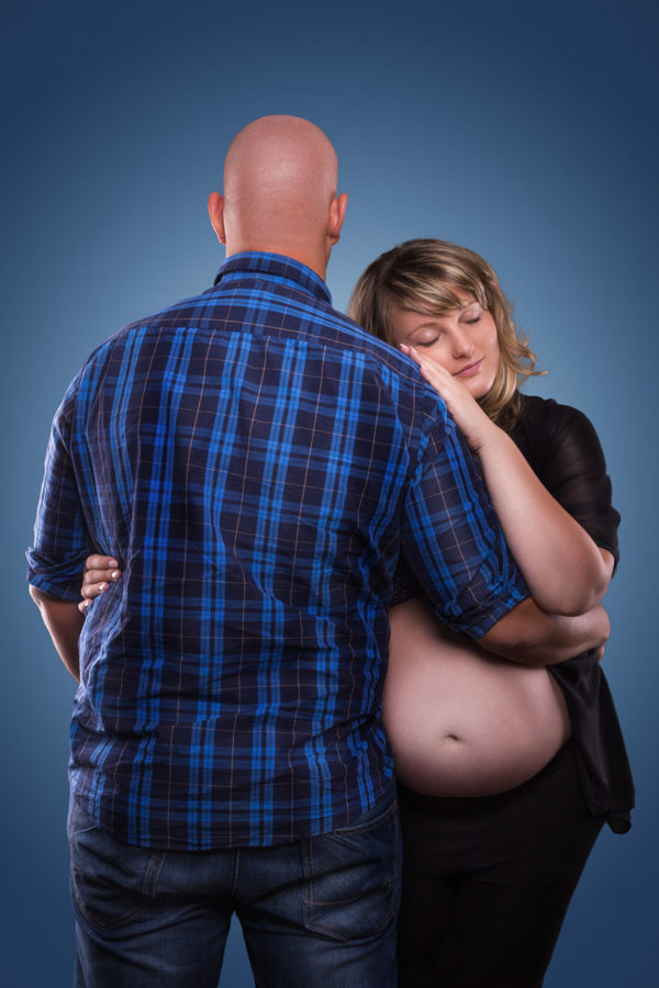 Fotograf Schwarzwald Babybauch Frau kuschelt an ihren Mann