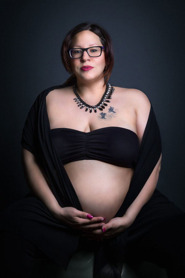 Fotograf Schwarzwald Babybauch Frau mit Brille posiert im Studio