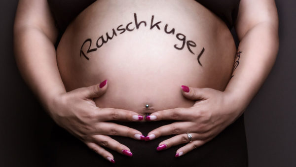 Fotograf Schwarzwald Babybauch Frau hält ihren Bauch mit der Aufschrift Rauschkugel