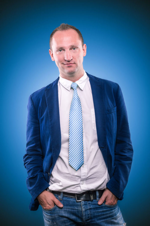 Fotograf Schwarzwald Business Mann mit Krawatte blauem Sakko vor blauem Hintergrund